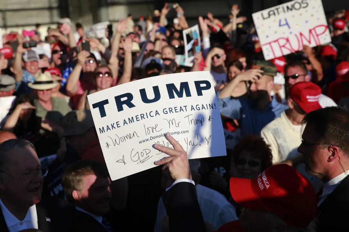 Republican presidential candidate Donald Trump, center, holds up a sign after autographing it during a rally at the Sacramento International Jet Center, in Calif., on June 1, 2016. (AP Photo/Jae C. Hong)
