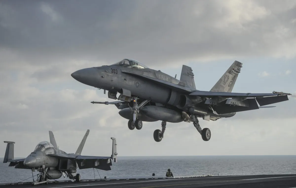 A F/A-18 Hornet lands aboard the nuclear-powered aircraft carrier USS Harry S. Truman at an undisclosed position in the Mediterranean Sea, south of Sicily, Thursday, Dec. 3, 2015. (AP Photo/Andrew Kravchenko, Pool)