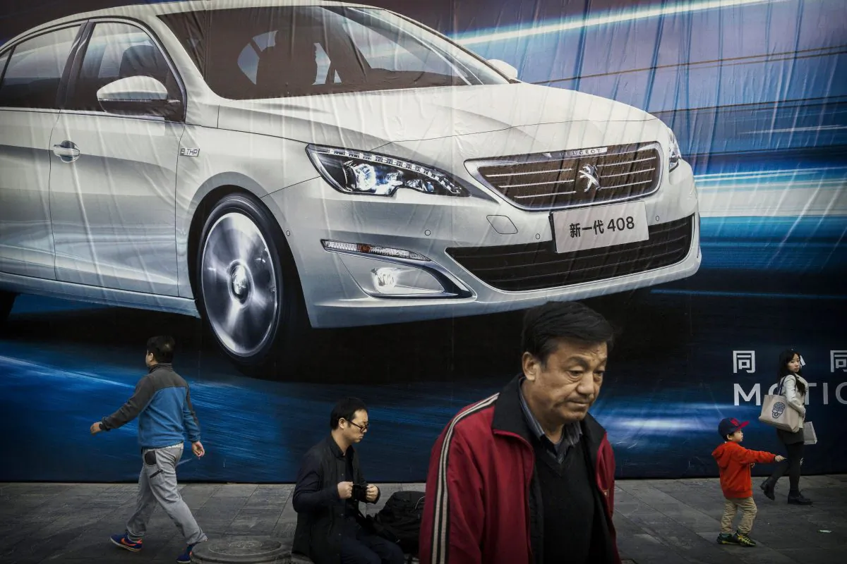 Chinese walk past an advertisement for a foreign auto maker on a wall on Oct. 27, 2014 in Beijing, China. The Chinese leaders economic reform plan face several structural obstacles. (Kevin Frayer/Getty Images)