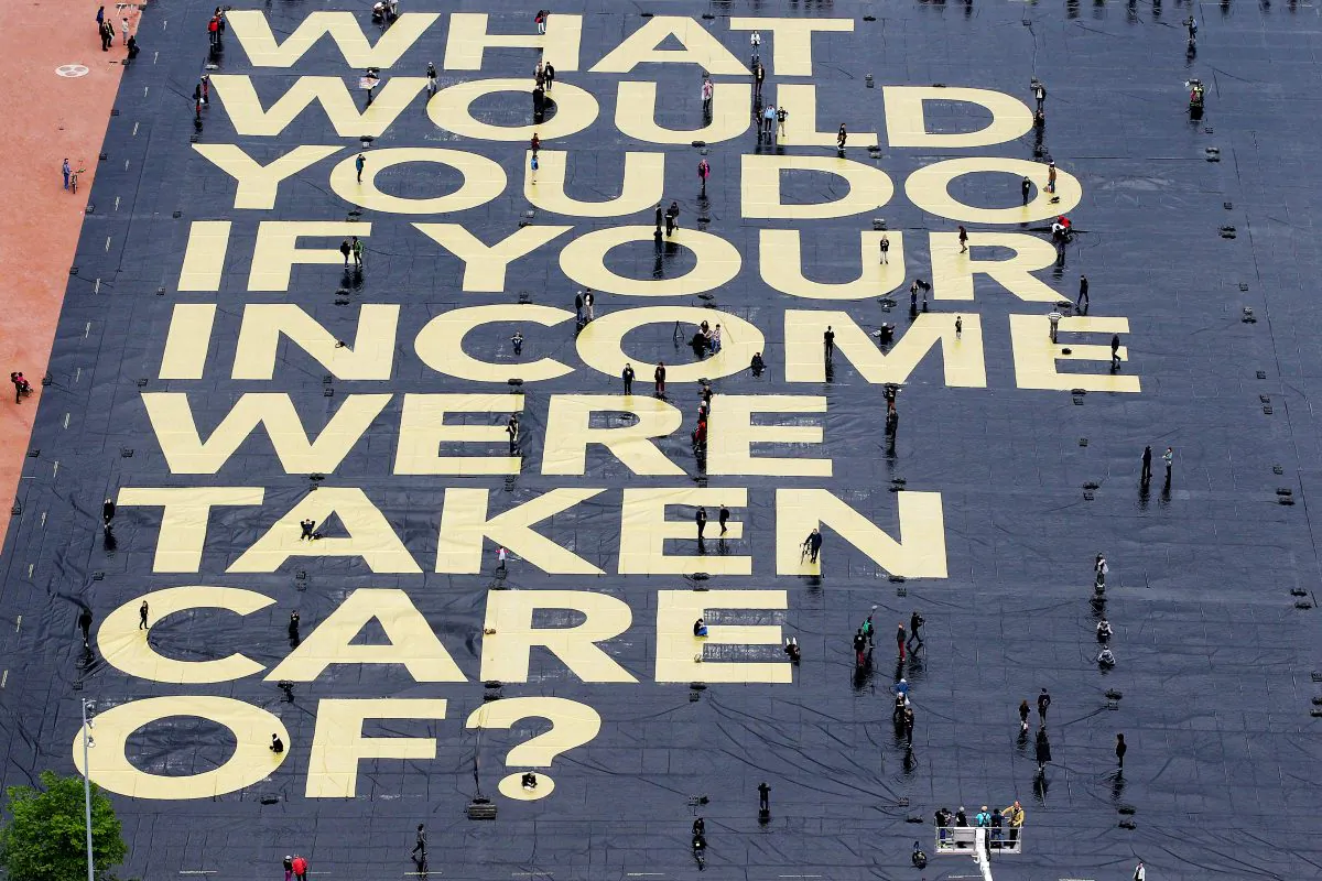 A huge poster reading “What would you do if your income were taken care of?” is pictured on the Plaine de Plainpalais square in Geneva, Switzerland, on May 14, 2016. The poster hints at a national referendum on June 5, were Swiss voters will have to decide on the introduction of an unconditional basic income for all. (Magali Girardin/Keystone via AP)