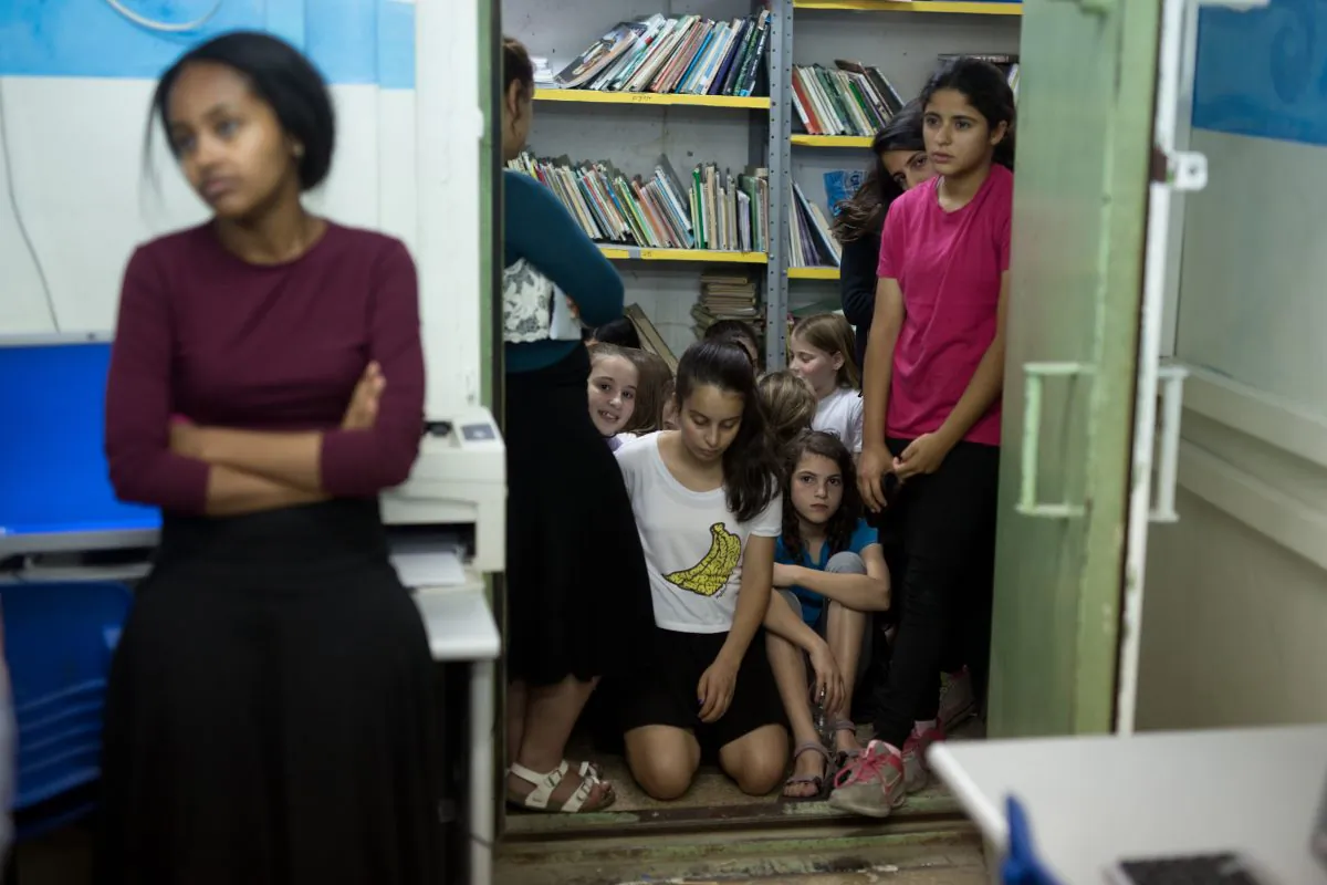 Israeli schoolchildren gather in a bomb shelter at a school in Jerusalem after sirens sounded across Israel as part of country-wide massive civil defence exercise aimed at preparing the country for air or missile attacks involving non-conventional weapons on June 2, 2015. (Photo credit should read MENAHEM KAHANA/AFP/Getty Images)