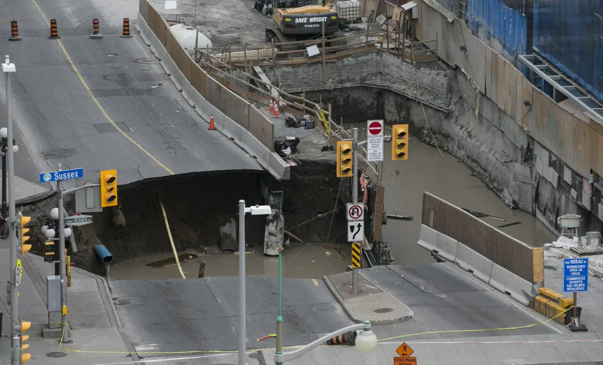 A large portion of Rideau Street in downtown Ottawa caved in on June 8, 2016, causing a massive sinkhole that knocked out power to the majority of the downtown area. (Chris Roussakis/AFP/Getty Images)