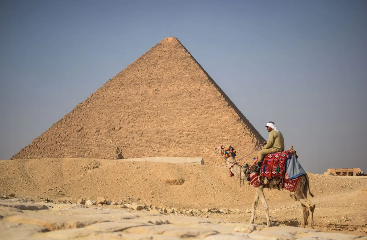 An Egyptian man rides a camel in front of one the Giza pyramids in the southern Cairo Giza district on Jan. 20, 2016. (Mohamed El-Shahed/AFP/Getty Images)