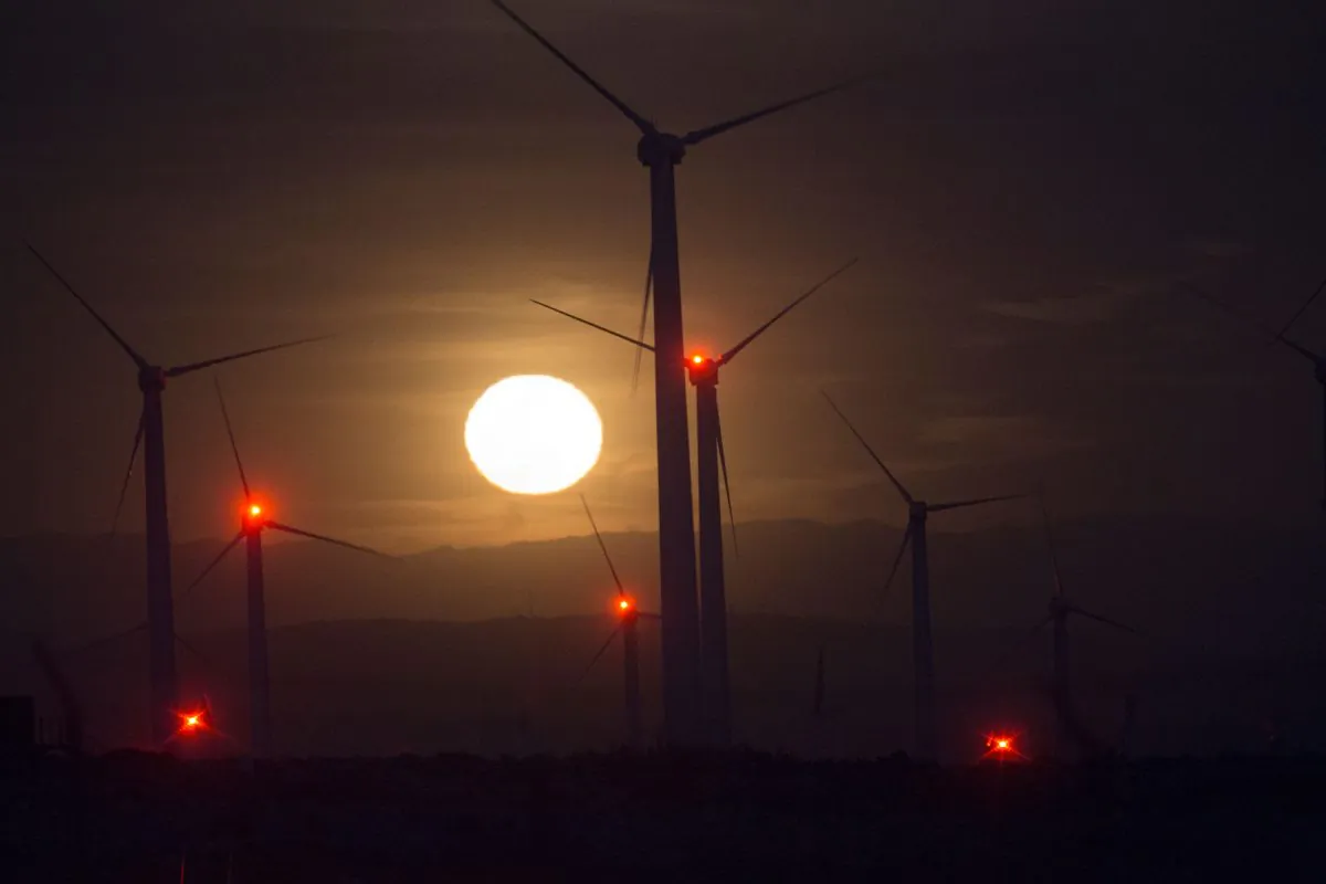 The moon rises behind electric energy generating wind turbines seen on a wind farm in the San Gorgonio Pass area, near Palm Springs, Calif., on Earth Day, on April 22, 2016. (David McNew/AFP/Getty Images)