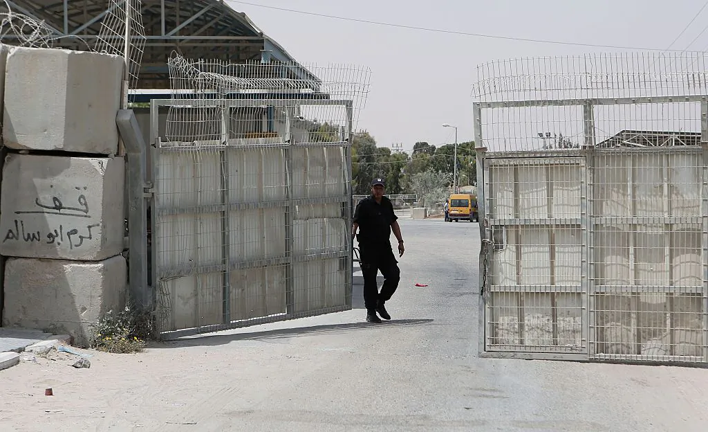 A Palestinian security officer closes the gate under Palestinian control at the Kerem Shalom crossing between Israel and the southern Gaza Strip, south of Rafah on June 7, 2015 after Israel closed, until further notice, the Erez crossing for people and the Kerem Shalom crossing for goods as Gaza militants resumed their rocket fire on southern Israel after warplanes blitzed the coastal enclave. AFP PHOTO / SAID KHATIB        (Photo credit should read SAID KHATIB/AFP/Getty Images)