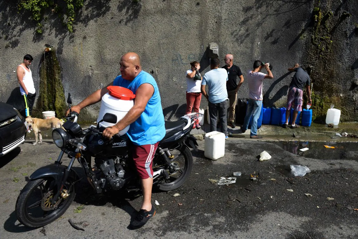 People line up to fill jerry cans with water from the Wuaraira Repano mountain in Caracas on Jan. 21, 2016. Venezuela suffers a severe water shortage, which the government attributes to the delay in the arrival of the rainy season for the third consecutive year. (Federico Parra/AFP/Getty Images)