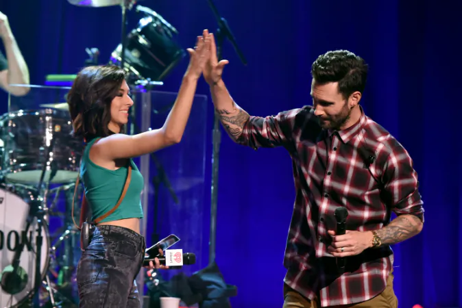Singers Christina Grimmie (L) and Adam Levine speak onstage during the iHeartRadio Album Release Party with Maroon 5 LIVE on the CW at iHeartRadio Theater in Burbank, Calif., on Aug. 26, 2014. (Kevin Winter/Getty Images for Clear Channel)