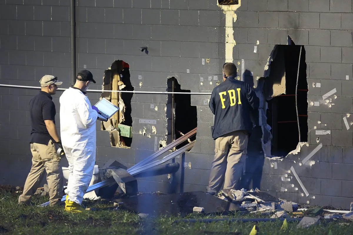 Police officials investigate the back of the Pulse nightclub after a shooting involving multiple fatalities at the nightclub in Orlando, Fla., Sunday, June 12, 2016. (AP Photo/Phelan M. Ebenhack)