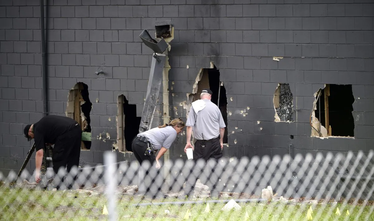 Police officials investigate the back of the Pulse nightclub after a shooting involving multiple fatalities at the nightclub in Orlando, Fla., Sunday, June 12, 2016. (AP Photo/Phelan M. Ebenhack)