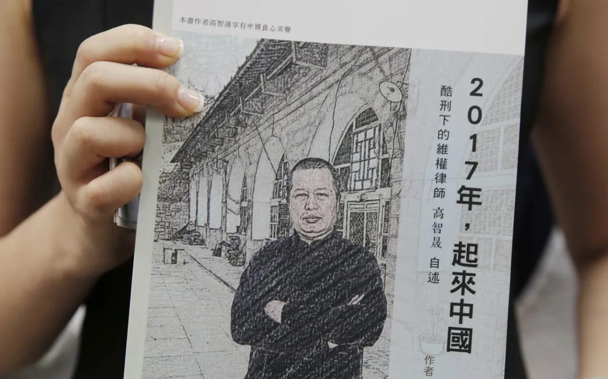 Grace Geng, the daughter of one of China's most prominent human rights lawyers, Gao Zhisheng, holds a book, titled “Stand Up China 2017 - China's Hope: What I Learned During Five Years as a Political Prisoner”, written by her father, at a news conference in Hong Kong, Tuesday, June 14, 2016. The book is a memoir by Gao in which he details the torture he says he endured while detained and jailed as well as three years of being held in solitary confinement. (AP Photo/Kin Cheung)