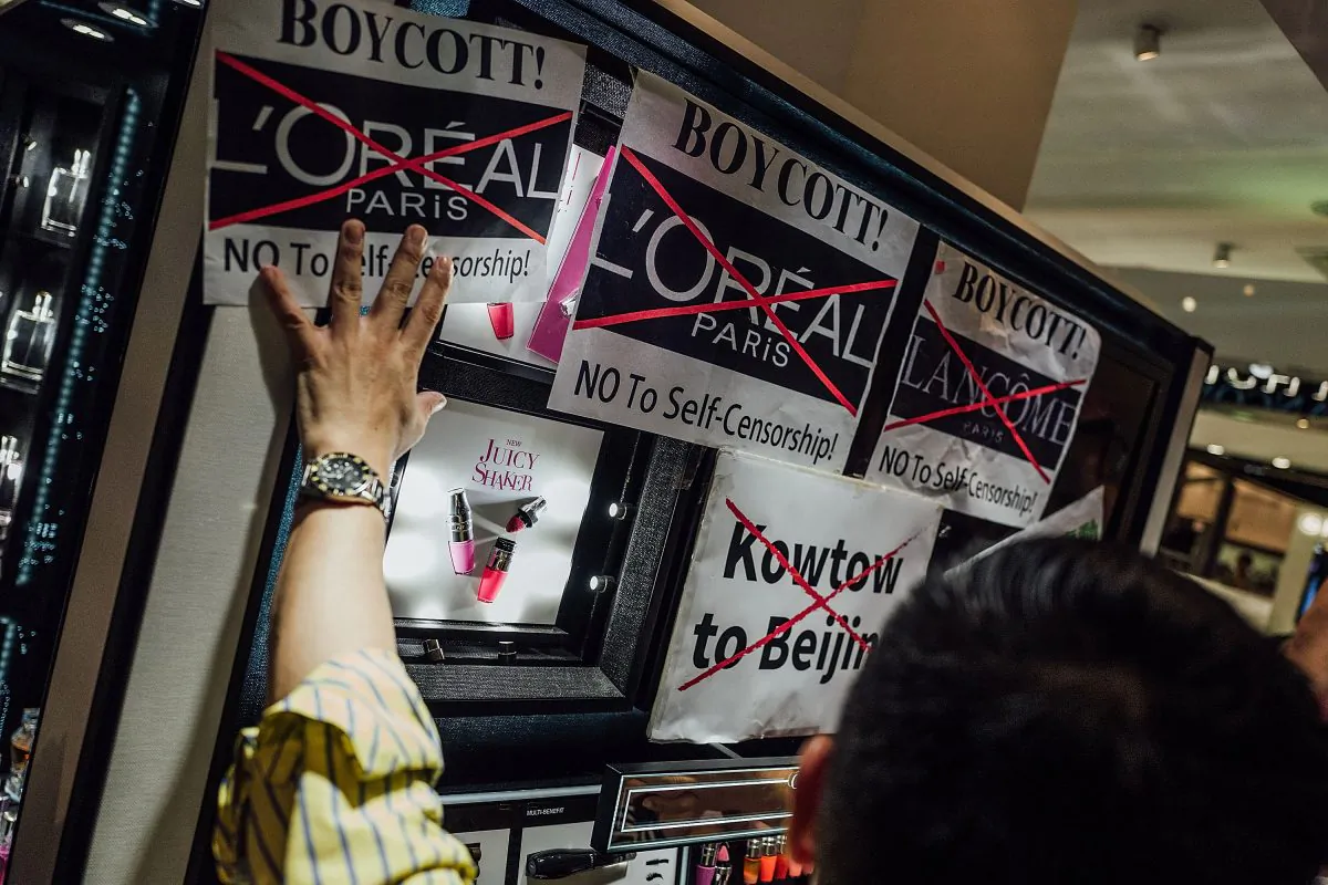 Protesters hold placards and shout slogans as they take part in a rally against French cosmetics brand Lancome at the store front of Lancome cosmetics in Causeway Bay, Hong Kong, on on June 8, 2016. (Anthony Kwan/Getty Images)