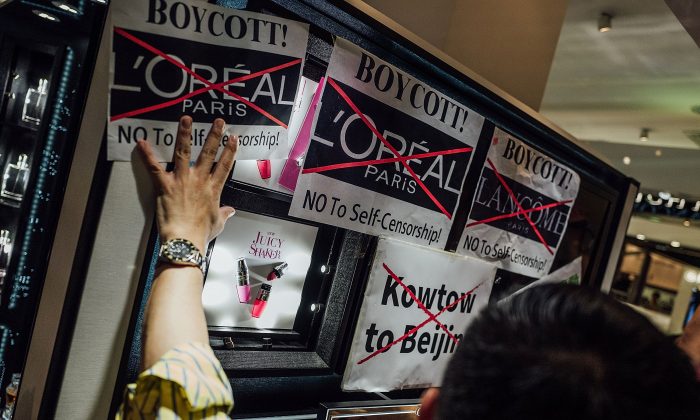 Protesters hold placards and shout slogans as they take part in a rally against French cosmetics brand Lancome at the store front of Lancome cosmetics in Causeway Bay, Hong Kong, on on June 8, 2016. (Anthony Kwan/Getty Images)