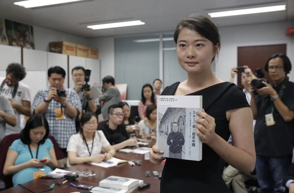 Grace Geng, the daughter of one of China's most prominent human rights lawyers Gao Zhisheng, presents a book authored by her father at a news conference in Hong Kong, Tuesday, June 14, 2016. The book, titled “Stand Up China 2017 - China’s Hope: What I Learned During Five Years as a Political Prisoner” is a memoir by Gao in which he details the torture he says he endured while detained and jailed as well as three years of being held in solitary confinement. Before being detained and jailed, Gao was a leading figure in the country's small community of rights lawyers and was admired for his bold defense of politically sensitive members of the banned Falun Gong spiritual movement and farmers with land disputes. (AP Photo/Kin Cheung)