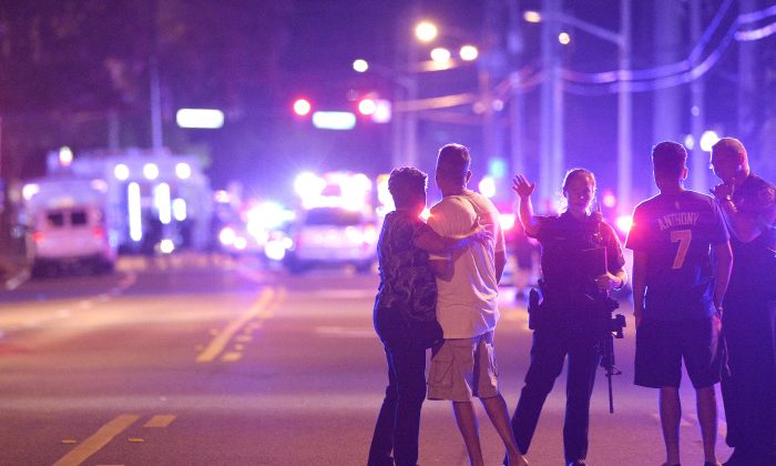 Orlando Police officers direct family members away from a fatal shooting at Pulse Orlando nightclub in Orlando, Fla., on June 12, 2016. (AP Photo/Phelan M. Ebenhack)