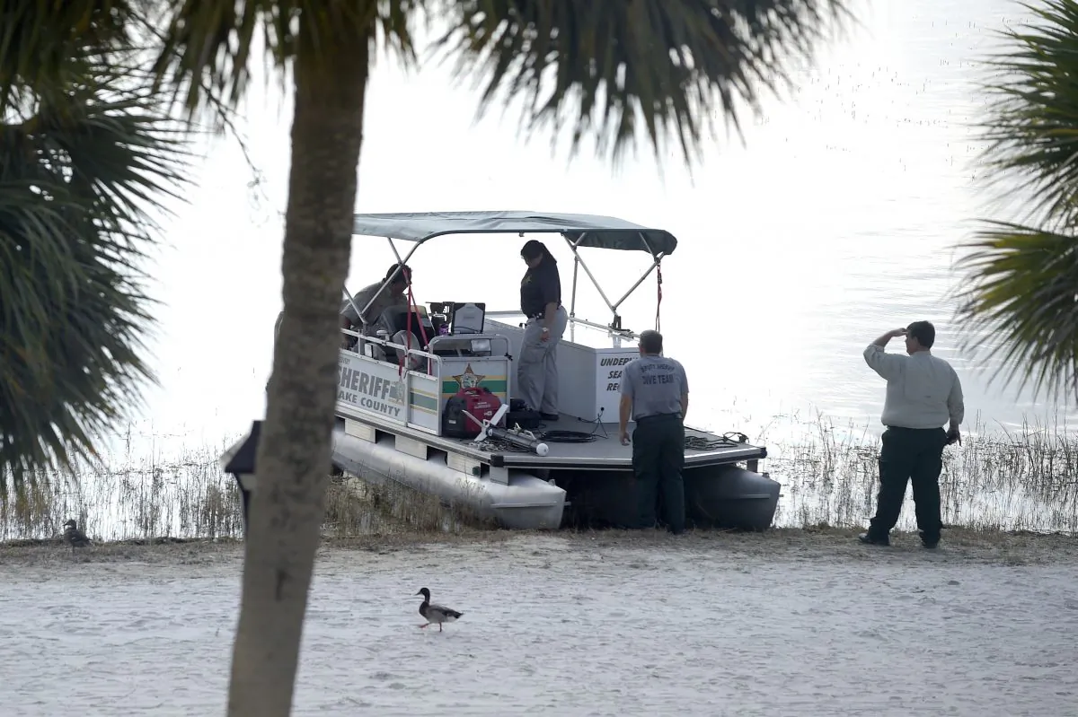 Law enforcement officials search the Seven Seas Lagoon outside the Grand Floridian Resort & Spa on Wednesday, June 15, 2016, in Lake Buena Vista, Fla., after a two-year-old toddler was dragged into the lake by an alligator. (AP Photo/Phelan M. Ebenhack)