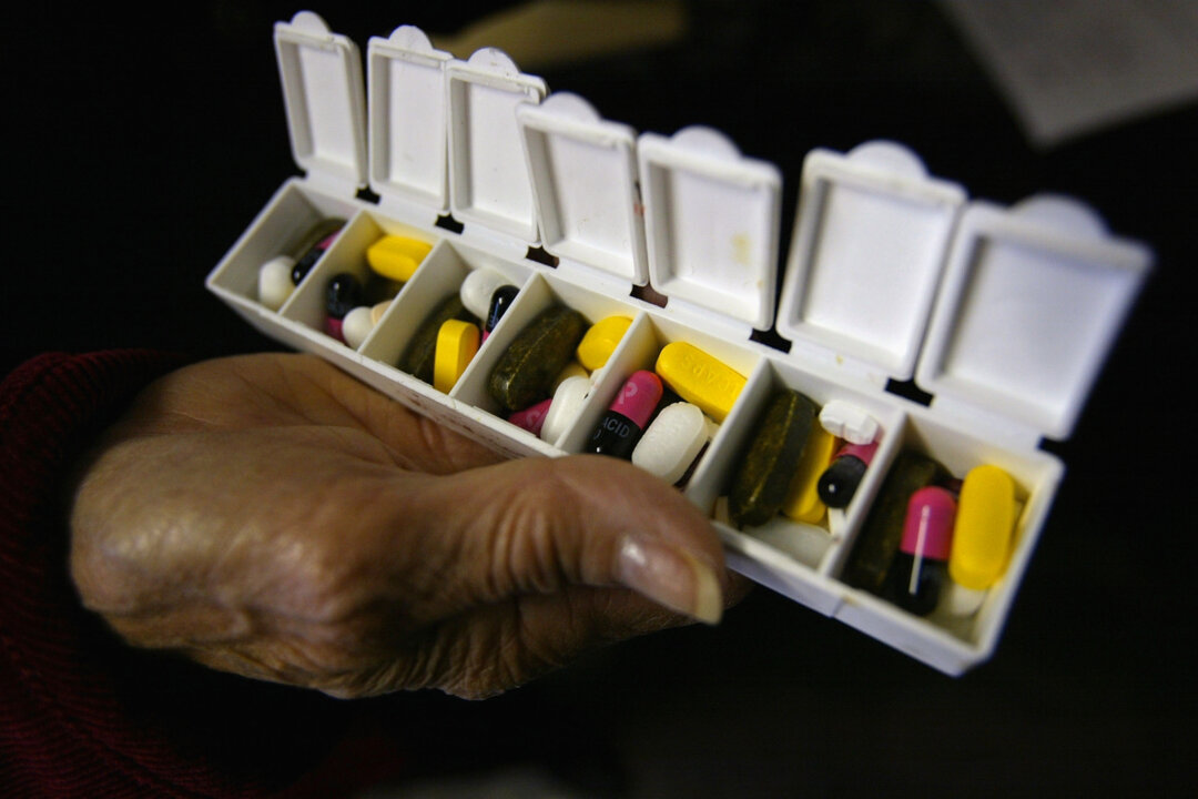 A woman displays a box of pills for her asthma and high blood pressure condition in New York City on Oct. 12, 2004. (Spencer Platt/Getty Images)
