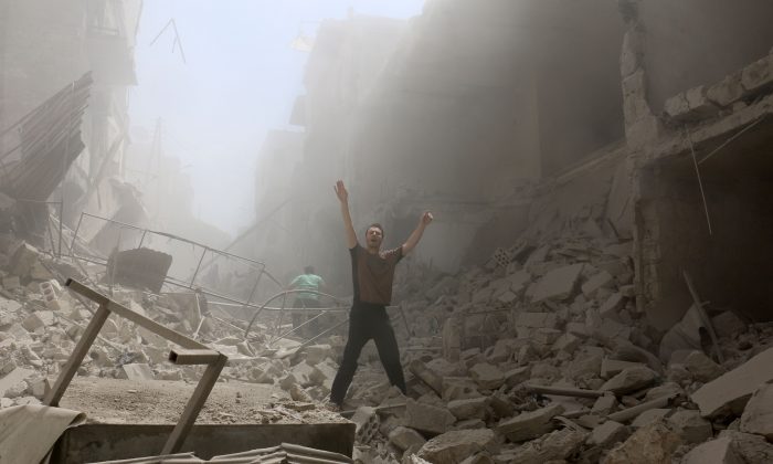 A man gestures amid the rubble of destroyed buildings following a reported airstrike on the rebel-held neighborhood of al-Kalasa in the northern Syrian city of Aleppo, on April 28, 2016. (Ameer Alhalbi/AFP/Getty Images)