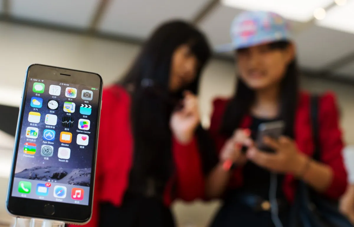 Chinese girls check out the iPhone 6 in an Apple store in Shanghai on October 17, 2014. ( Johannes Eisele/AFP/Getty Images)