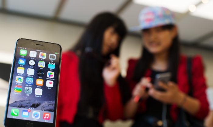 Chinese girls check out the iPhone 6 in an Apple store in Shanghai on October 17, 2014. ( Johannes Eisele/AFP/Getty Images)