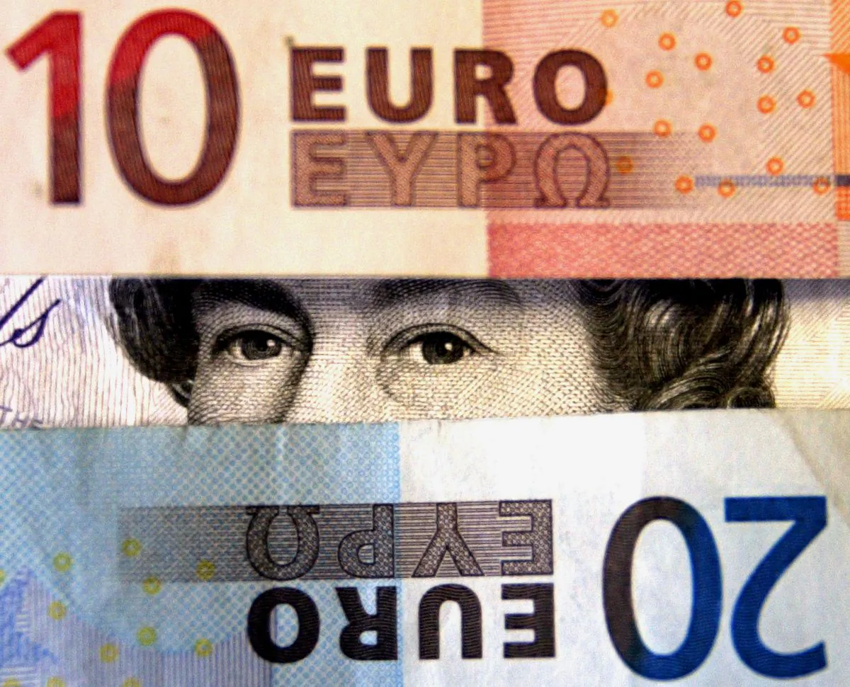 The image of Queen Elizabeth II on a 20 sterling note is seen between Euro banknotes in London on May 14, 2003. (Ian Waldie/Getty Images)