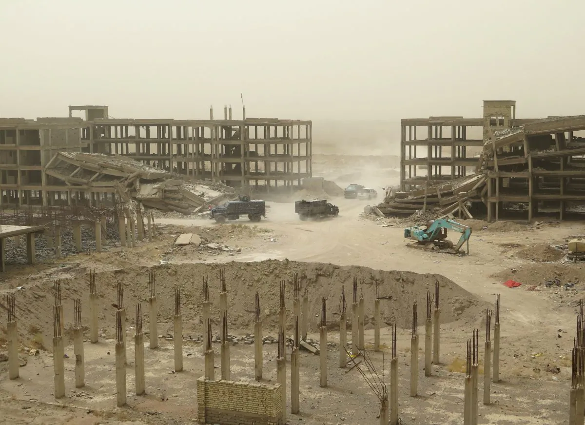 Iraqi forces vehicles drive past damaged buildings in Fallujah's southern Hayakel neighborhood during an operation to retake areas from the Islamic State on June 16, 2016. (Jean Marc Mojon/AFP/Getty Images)