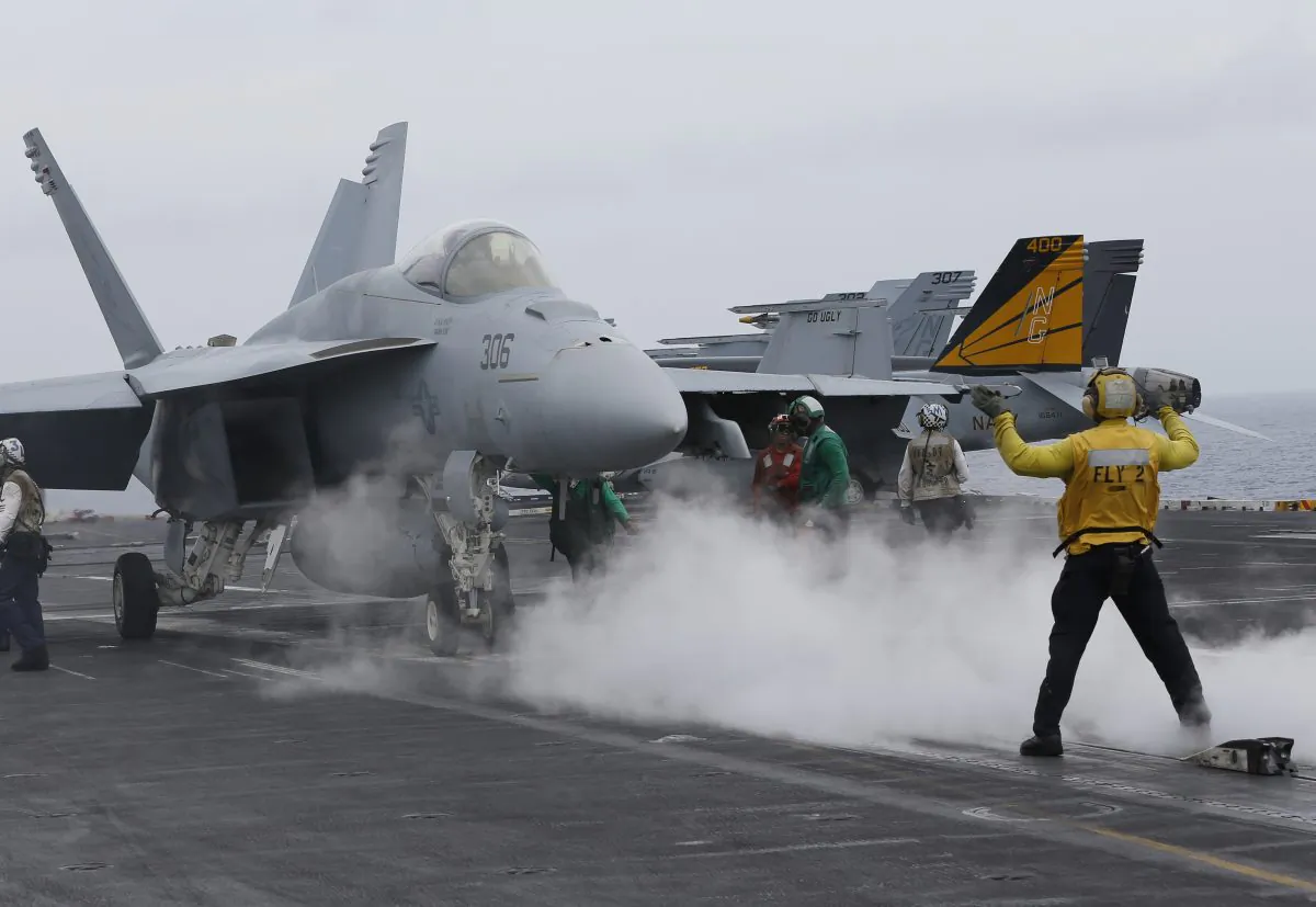 In this file photo, a flight deck director signals a fighter jet to move on the deck of the nuclear-powered aircraft carrier the USS John C. Stennis during joint military exercise between the United States, Japan, and India 180 miles east of Japan’s southernmost island of Okinawa on June 15, 2016. (AP Photo/Shizuo Kambayashi, File)