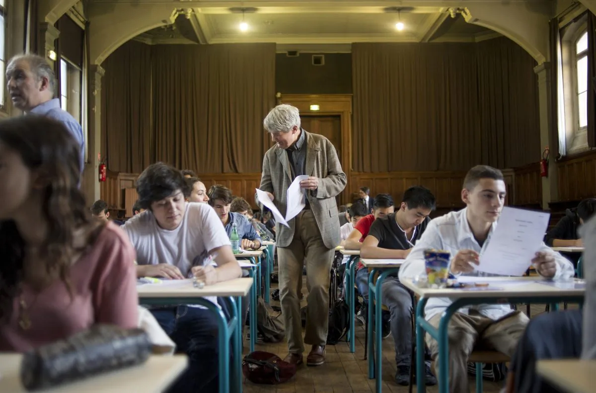 A teacher distributes final exams. (Fred Dufour/AFP/Getty Images)