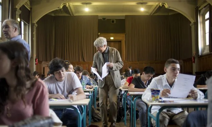 A teacher distributes final exams. (Fred Dufour/AFP/Getty Images)