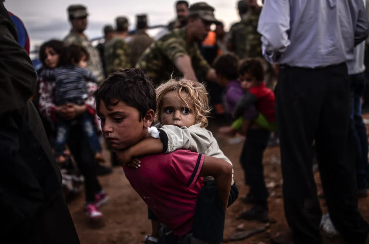 Syrian Kurdish people arrive at the border between Syria and Turkey after several mortars hit both side in the southeastern town of Suruc, Sanliurfa Province, on Sept. 29, 2014. (Bulent Kilic/AFP/Getty Images)
