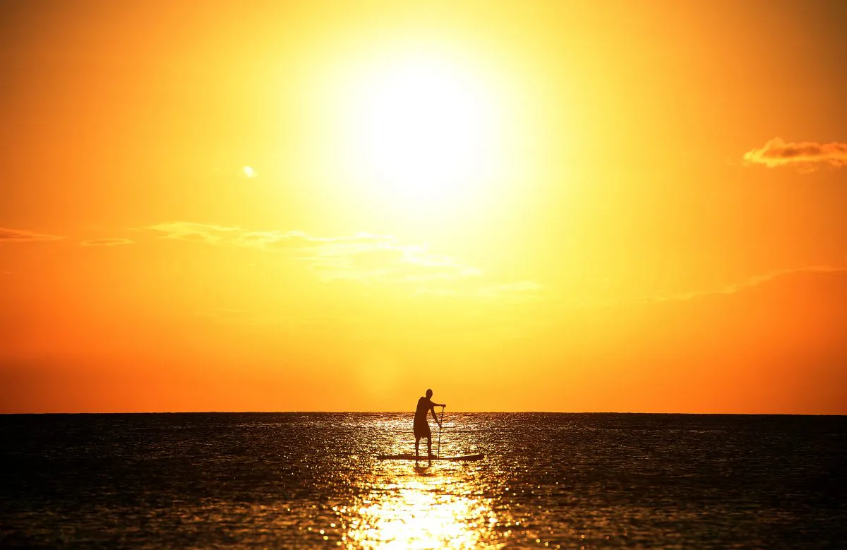 A man surf paddles near a beach as sun sets in Bridgetown, Barbados, on March 12, 2014. (Jewel Samad/AFP/Getty Images)