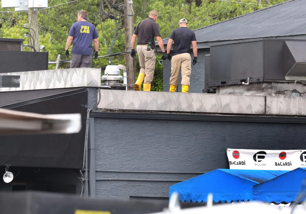 FBI lab personnel walk on the roof of the Pulse Nightclub Monday, June 20, 2016, investigating the mass shooting scene in Orlando. (Red Huber/Orlando Sentinel via AP)