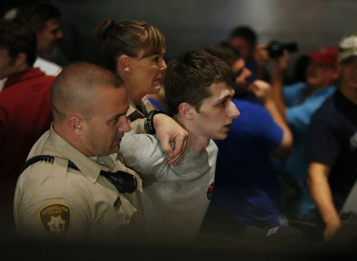In this June 18, 2016, file photo, police remove protestor Michael Steven Sandford as Republican presidential candidate Donald Trump speaks at the Treasure Island hotel and casino in Las Vegas. Sandford, a British man accused of trying to take a police officer's gun and kill Donald Trump during a weekend rally in Las Vegas, will not be released on bail. Federal Magistrate Judge George Foley said at a hearing Monday that Sandford was a potential danger to the community and a flight risk. (AP Photo/John Locher, File)