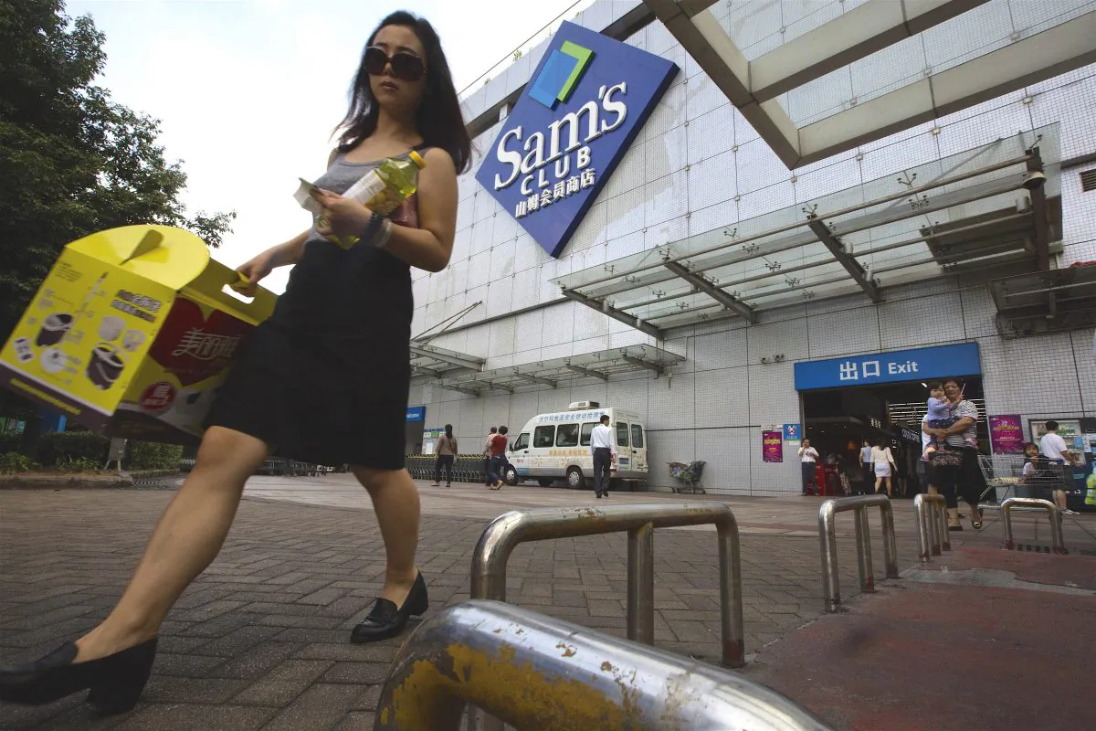 A woman walks out from a Sam's Club in Shenzhen, Guangdong Province, China, on Nov. 15, 2015. (Ng Han Guan/AP Photo)
