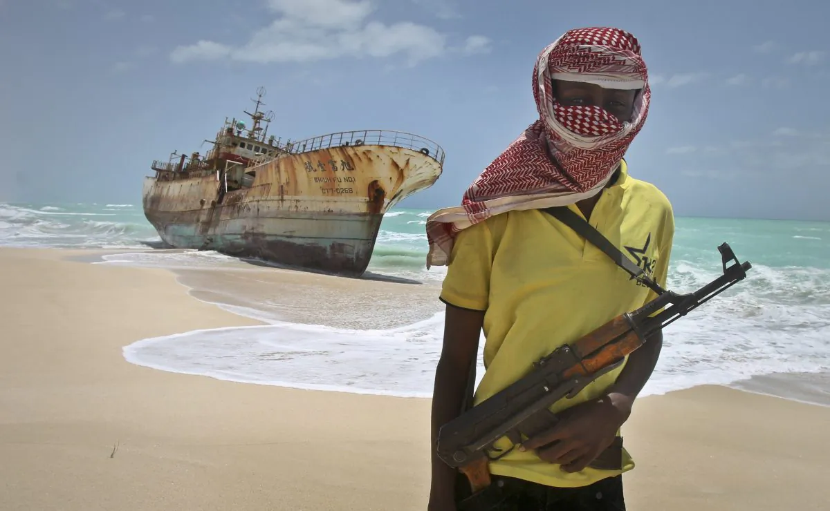 A masked Somali pirate stands near a Taiwanese fishing vessel that washed up on shore after the pirates were paid a ransom and released the crew, in the once-bustling pirate den of Hobyo, Somalia, on Sept. 23, 2012. (Farah Abdi Warsameh/AP Photo)