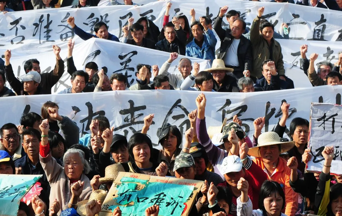 Villagers hold banners and placards during a protest rally by residents of Wukan, a fishing village in the southern province of Guangdong, as they demand the government take action over illegal land grabs and the death in custody of a local leader on Dec. 19, 2011. (STR/AFP/Getty Images)