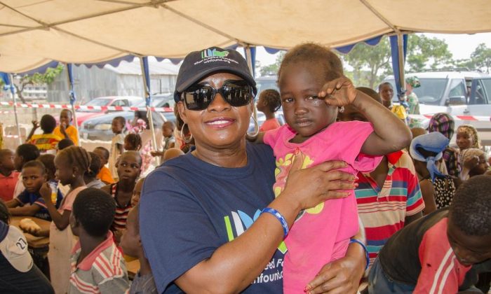 When In Need Foundation President Ms. Chetachi Ecton holds a child at the Kuchingoro IDP camp in the Galadimawa area of Abuja, Nigeria. (When In Need Foundation)