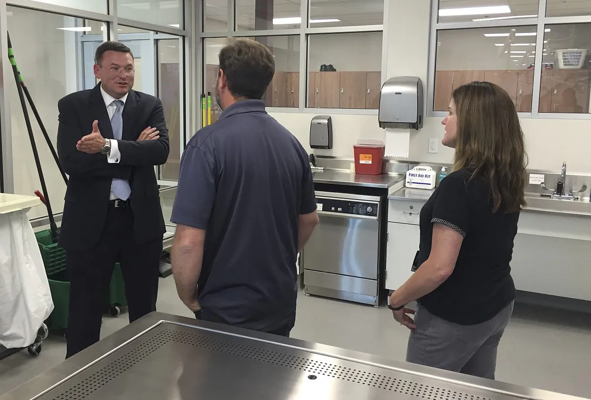In this June 20, 2016 photo, Dr. Robert Hasty, the dean of the for-profit Idaho College of Osteopathic Medicine, talks with Idaho State University Meridian Health Science Center employees Chris Wilson, center, and Nancy Carpenter in Meridian, Idaho. ICOM and ISU have reached an agreement that will allow the for-profit school's students to use the public university's facilities when ICOM opens in 2018. (AP Photo/Rebecca Boone)
