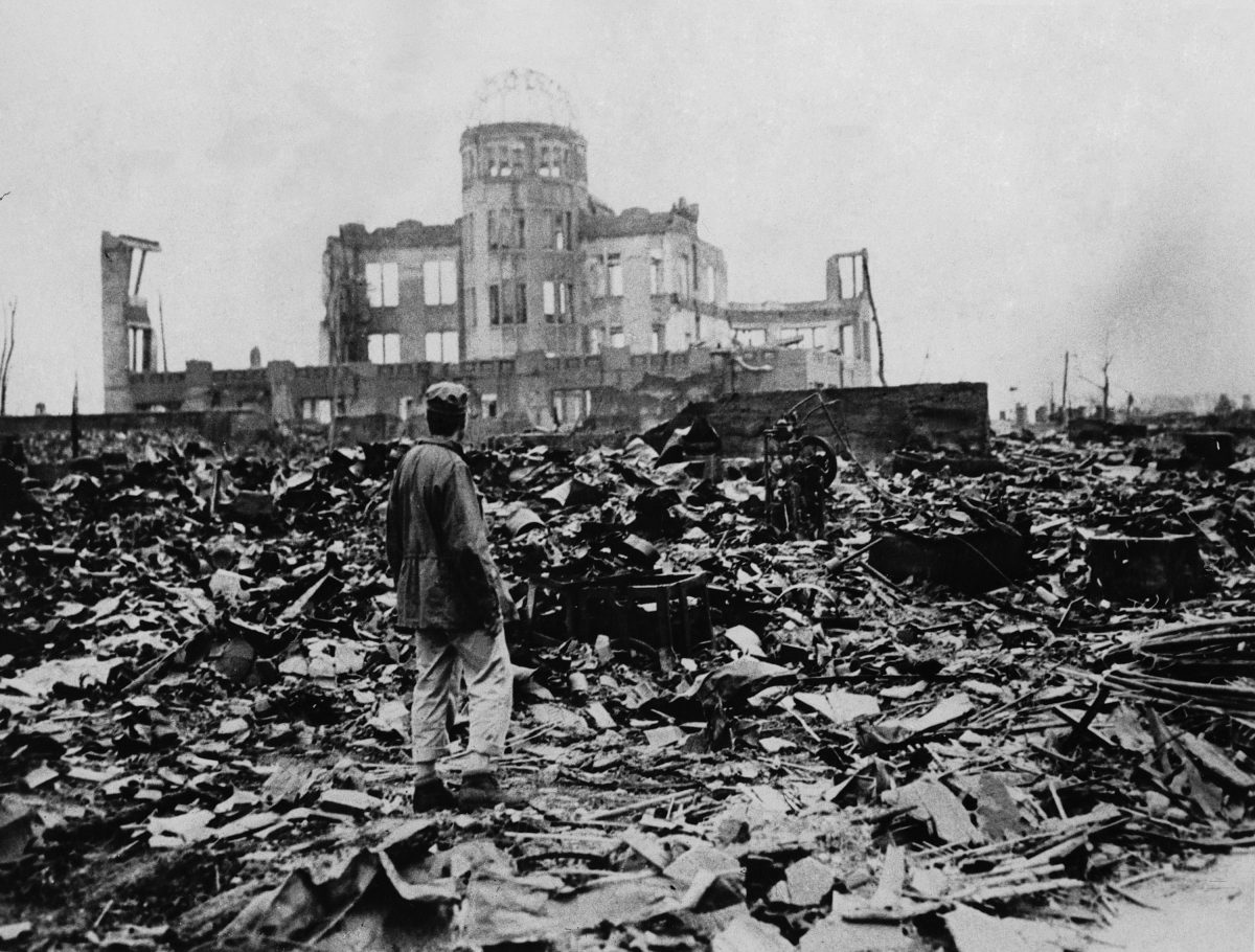 [1945年8月6日、日本の広島で原爆が爆発したことによって残された廃墟の広がりを見ている男性。約14万人がここですぐに亡くなりました。（AP写真）