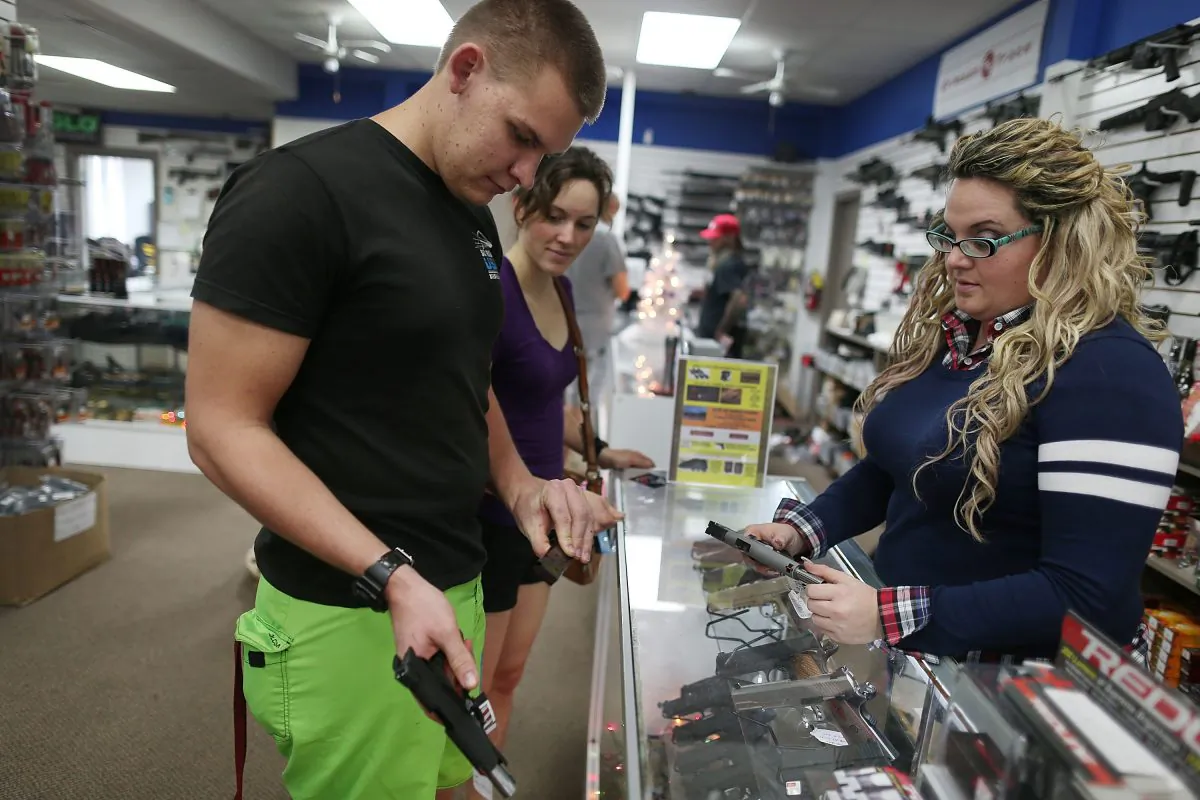 Sales clerk Allie Menz, (R) helps a couple with handguns at the National Armory gun store in Pompano Beach, Fla., on Dec. 23, 2015. (Joe Raedle/Getty Images)