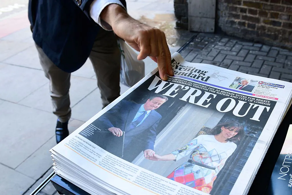 A man takes a copy of the London Evening Standard with the front page reporting the resignation of British Prime Minister David Cameron and the vote to leave the EU in a referendum, showing a pictured of Cameron holding hands with his wife Samantha as they come out from 10 Downing Street, in London on June 24, 2016.
(Leon Neal/AFP/Getty Images)