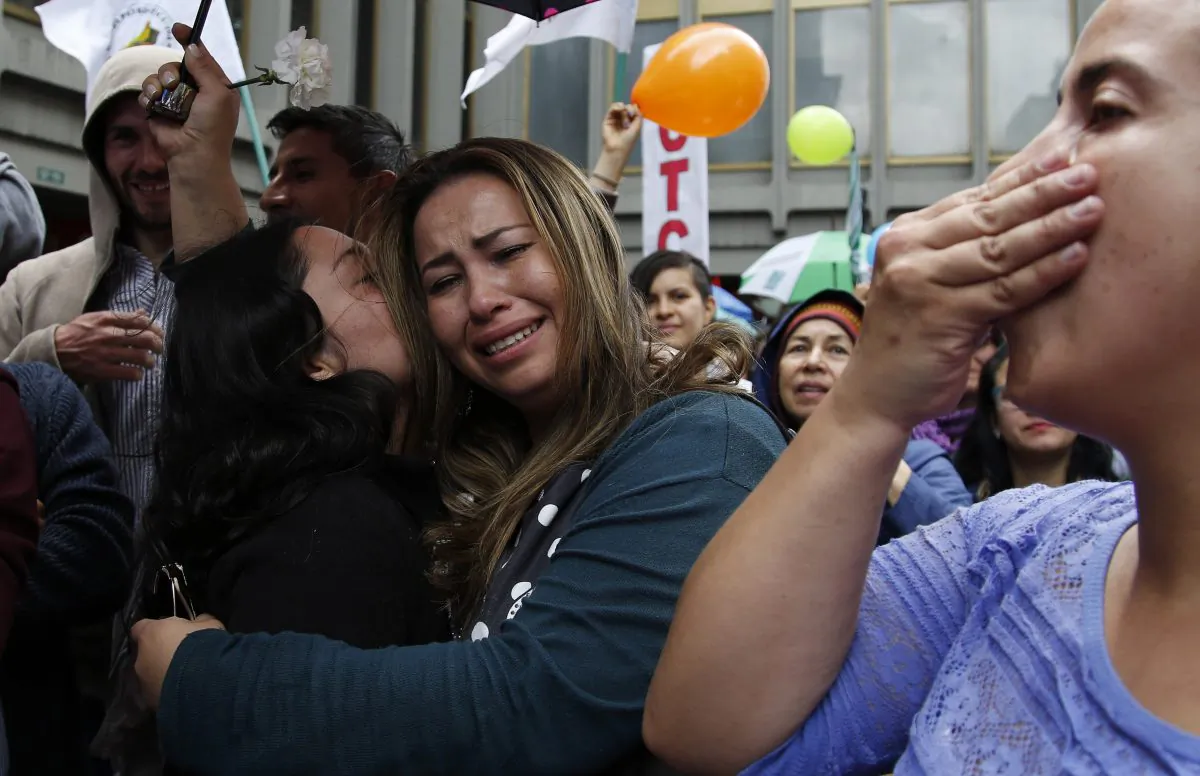 People celebrate the agreement between Revolutionary Armed Forces of Colombia, FARC, and Colombia's government, in Bogota, Colombia, Thursday, June 23, 2016. (AP Photo/Fernando Vergara)