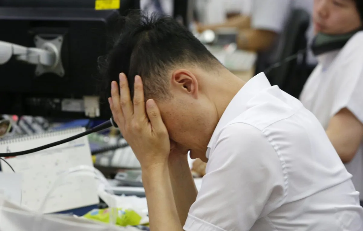 A currency trader rubs his eyes at the foreign exchange dealing room in Seoul, South Korea, Friday, June 24, 2016.  (AP Photo/Lee Jin-man)