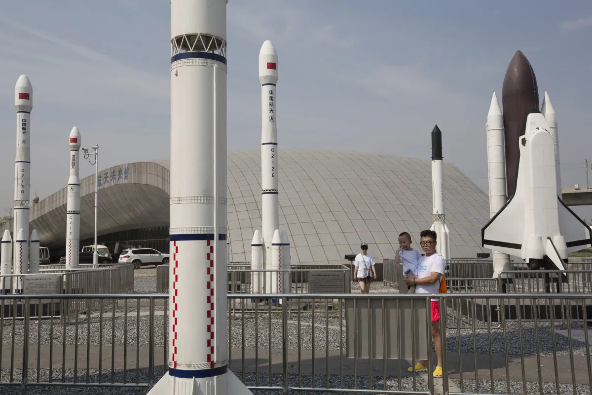 A man holds a child as they visit a park with replicas of foreign and domestic space vehicles displayed in Beijing, China, on June 26, 2016. (Ng Han Guan/AP Photo)
