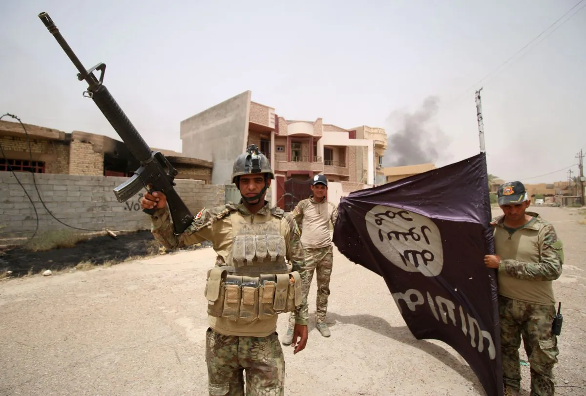 Iraqi pro-government forces hold an ISIS flag in the al-Dhubat II (Officers) neighborhood of Fallujah on June 19, 2016. (Haidar Mohammed Ali/AFP/Getty Images)