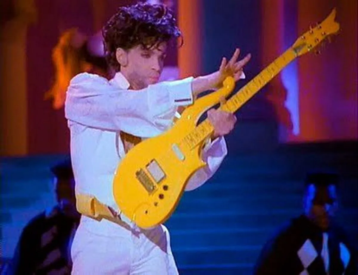 This photo provided by Heritage Auctions shows Prince playing his Yellow Cloud electric guitar.   Indianapolis Colts owner Jim Irsay has purchased the Yellow Cloud electric guitar that Prince used in numerous concerts until the mid-1990's. The NFL football team owner and collector of musical instruments paid $137,500 for the guitar at an auction in Beverly Hills Saturday, June 25, 2016. Heritage Auctions, which conducted the auction, says the solid body guitar was a favorite of the late musician from the late 1980's to the mid-1990's.  (Heritage Auctions via AP)