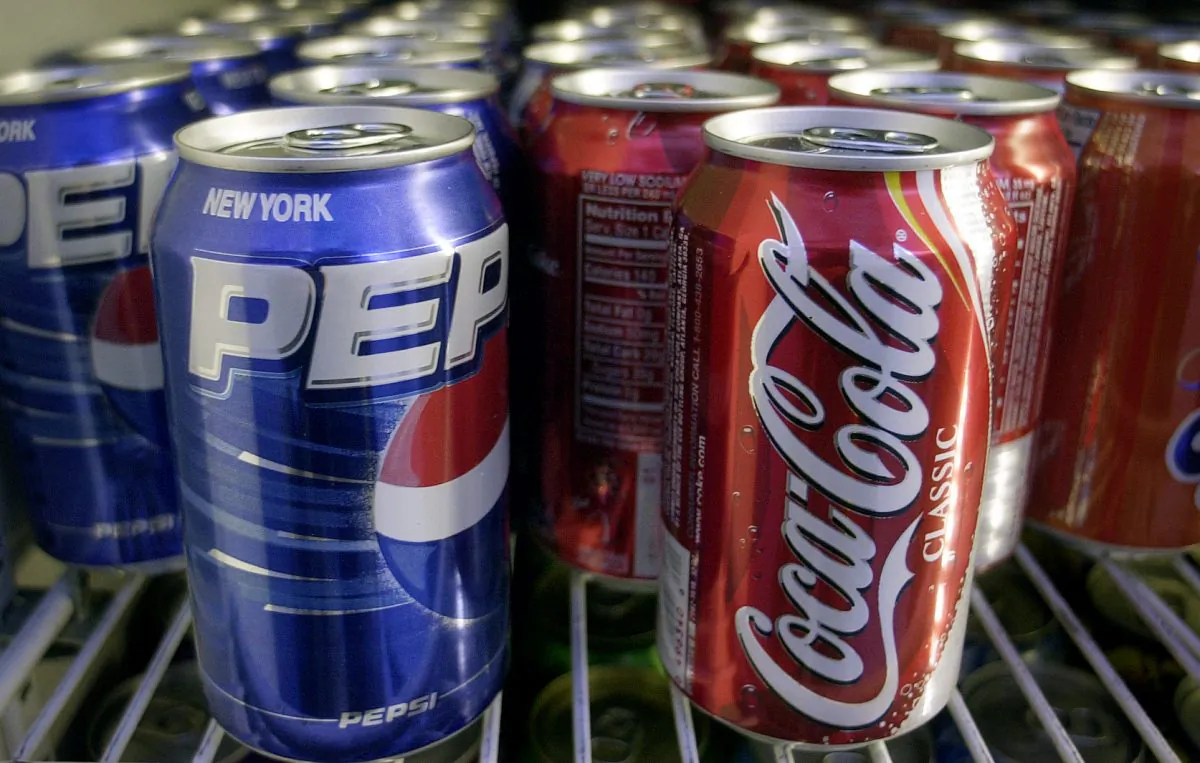 Cans of Pepsi and Coke are shown in a news stand refrigerator display rack in New York on April 22, 2005. (Mark Lennihan/AP Photo)