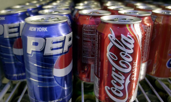 Cans of Pepsi and Coke are shown in a news stand refrigerator display rack in New York on April 22, 2005. (Mark Lennihan/AP Photo)