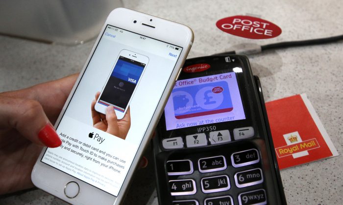 An iPhone is used to make an Apple Pay purchase at The Post Office in London, England, on July 14, 2015. (Peter Macdiarmid/Getty Images)