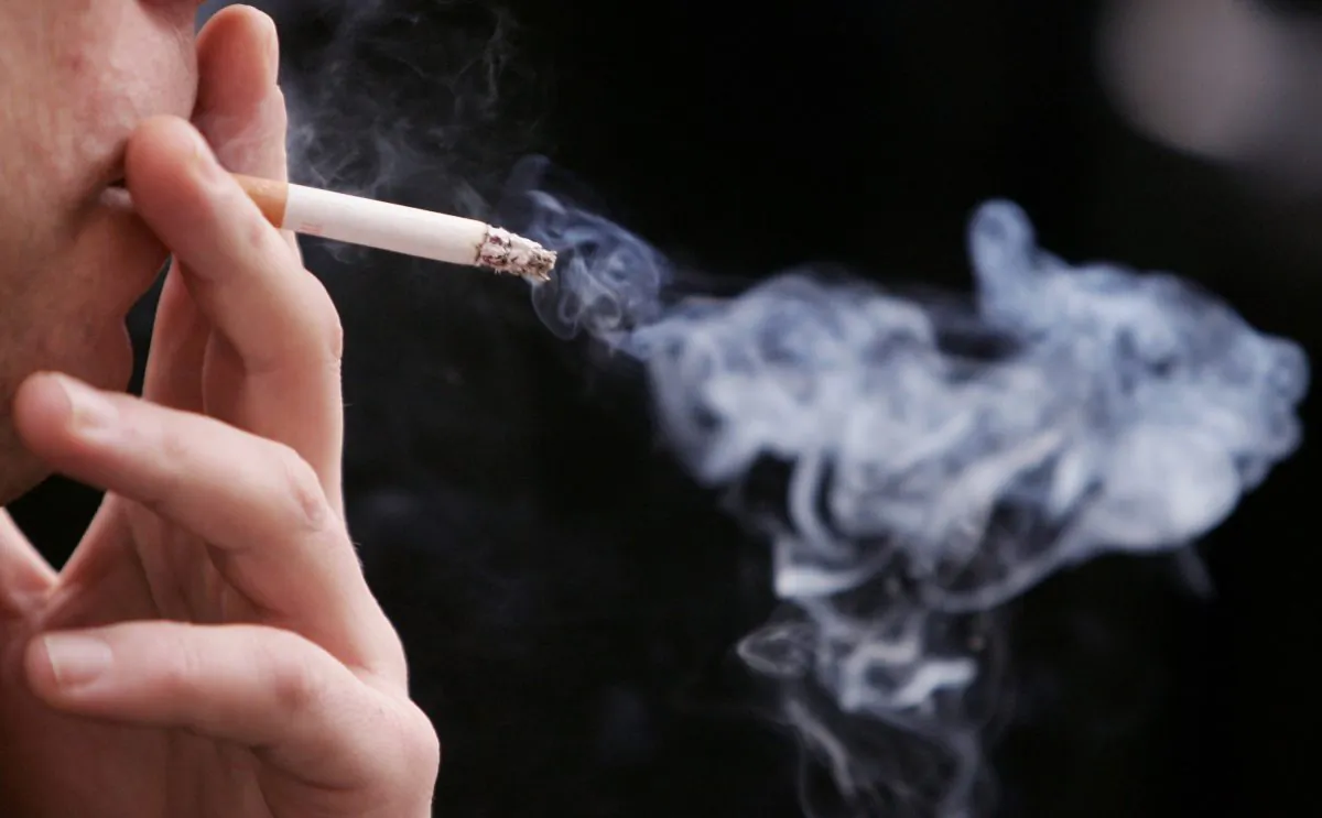 An man smokes a cigarette in the street outside his office in Paris, France, on Jan. 31, 2007. (Pascal Le Segretain/Getty Images)