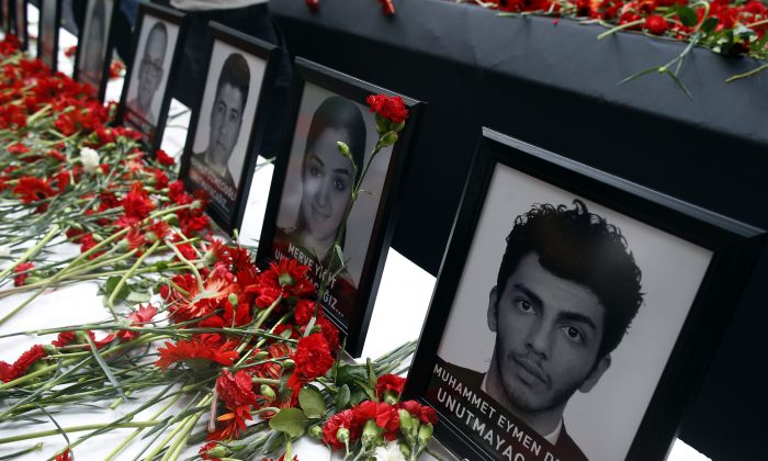 Photographs of victims were displayed among carnations as family members, colleagues and friends gather for a memorial ceremony at the Ataturk Airport in Istanbul, Thursday, June 30, 2016. (AP Photo/Emrah Gurel)